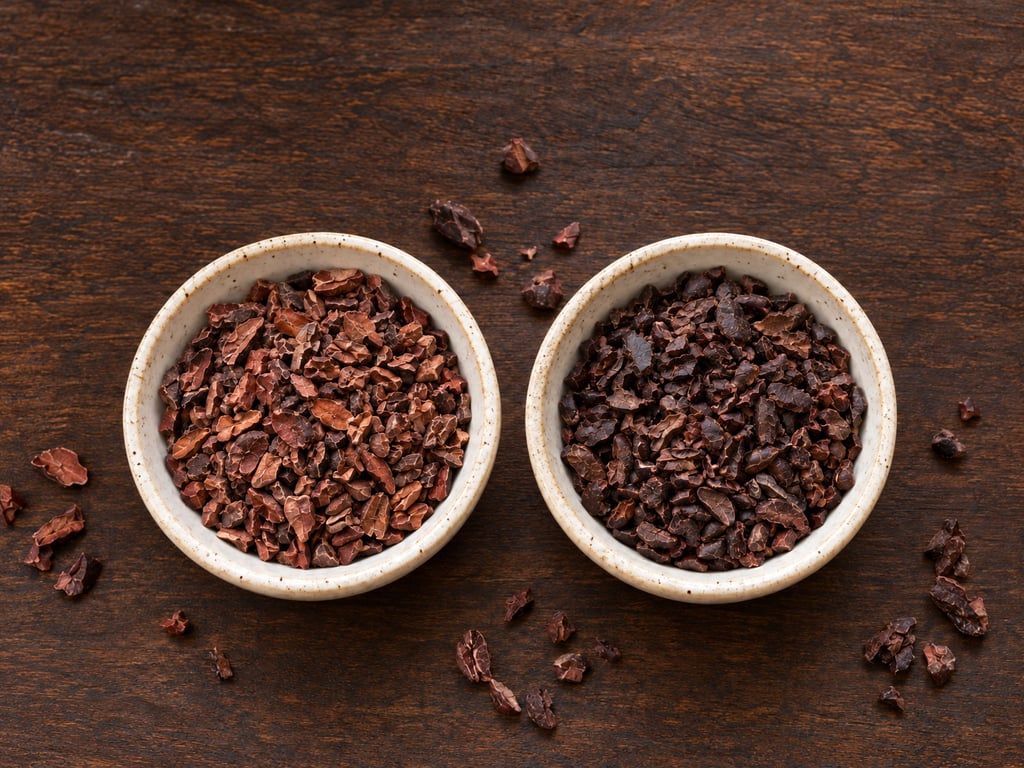 Two bowls of cacao nibs with different roast colors