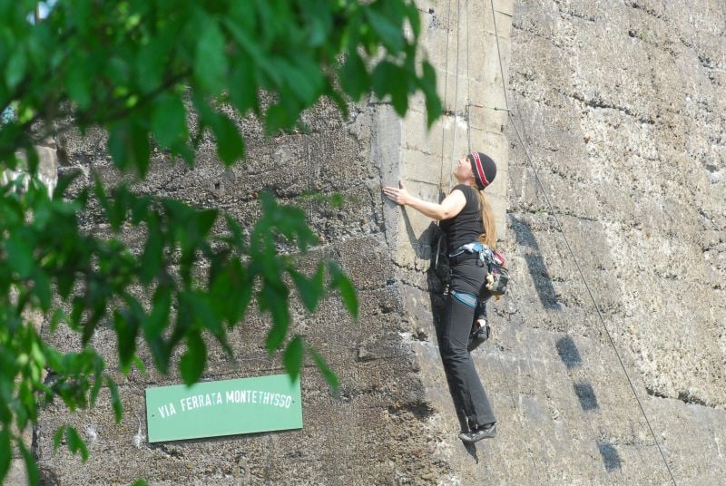 Frau klettert an Kletterwand hoch