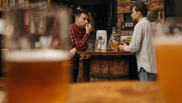 Zwei Männer trinken Bier und unterhalten sich auf einem der Weinfeste