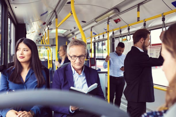 mann im bus liest beim pendeln ein buch
