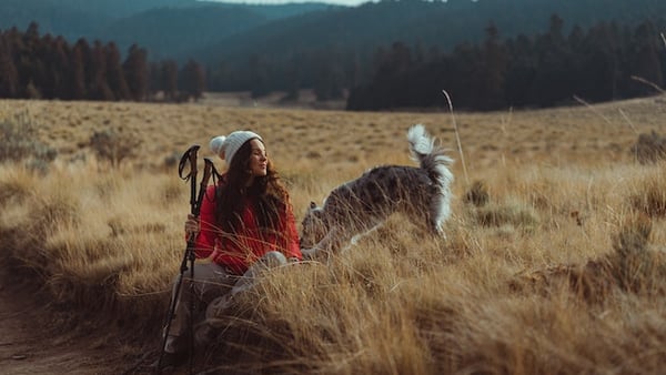 Frau mit Hund auf einem Feld