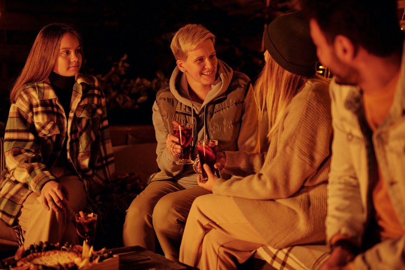 menschen trinken gemeinsam glühwein am lagerfeuer auf einem der weihnachtsmärkte