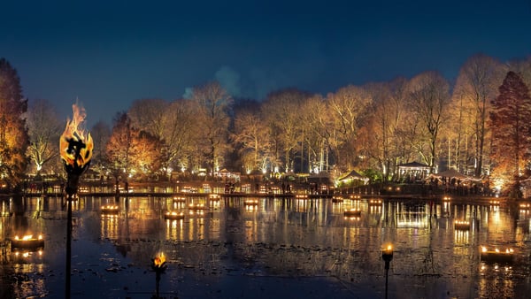 see mit beleuchteten bäumen und feuer auf einem der außergewöhnlichen weihnachtsmärkte