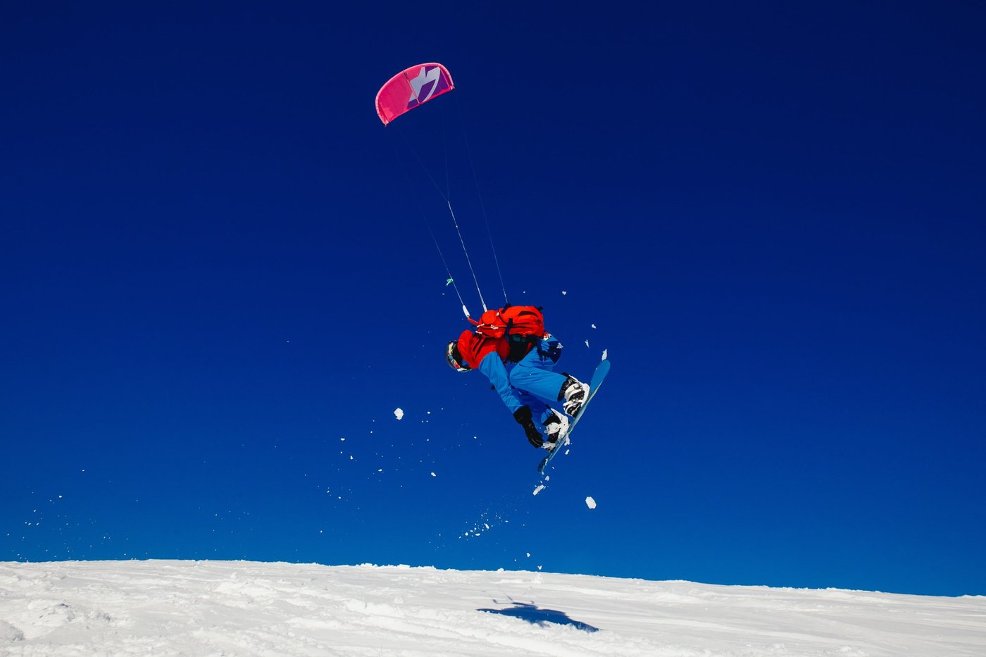 mann beim snowkiten auf einem hügel