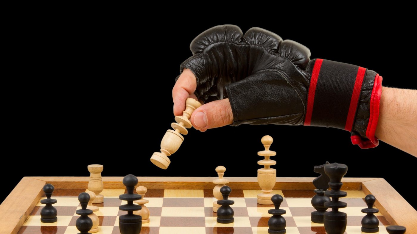 hand mit boxhandschuh spielt schach