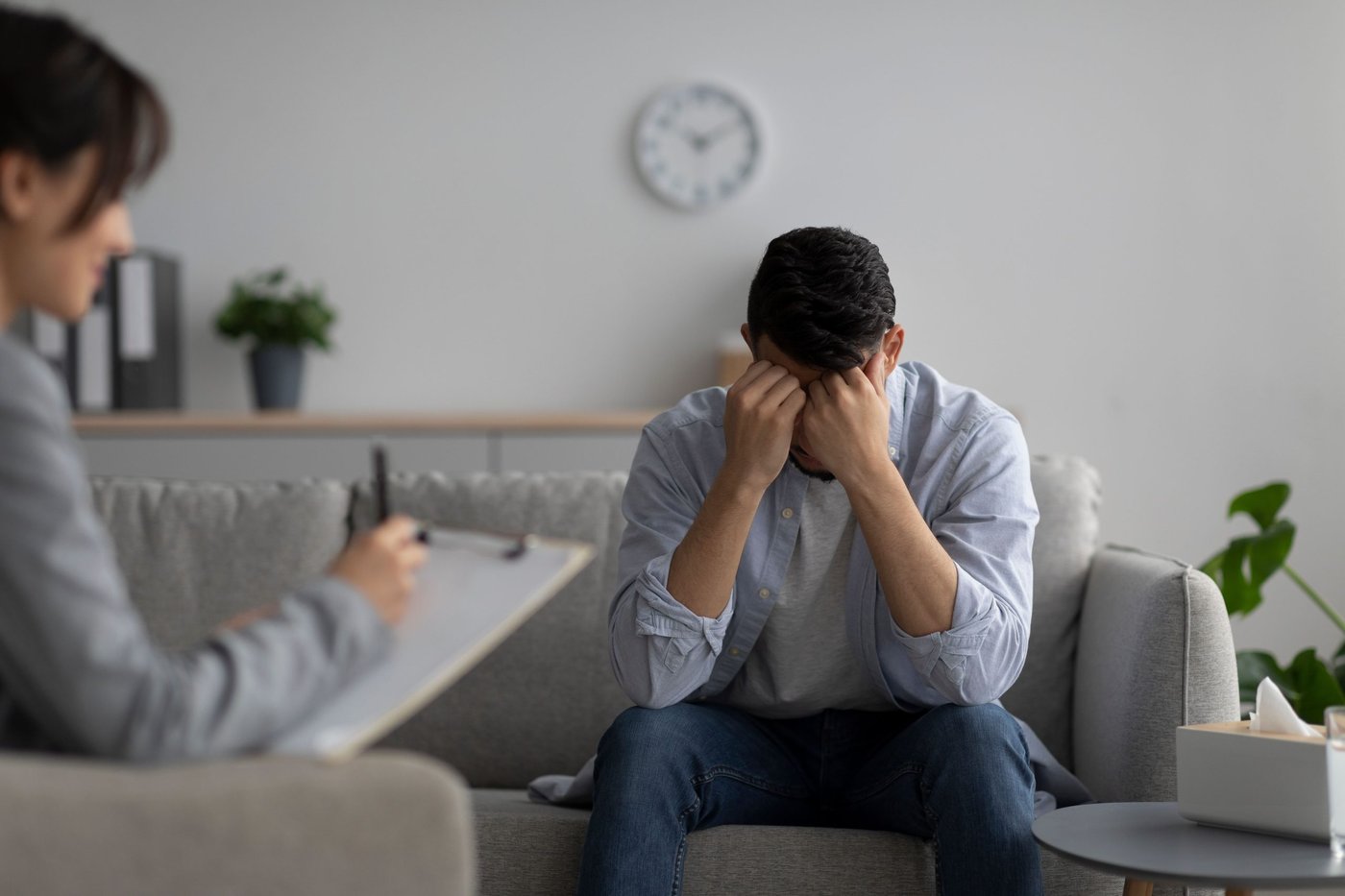 Mann sitzt beim Psychologen.