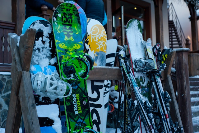 Mehrere Snowboards lehnen an einer Hütte