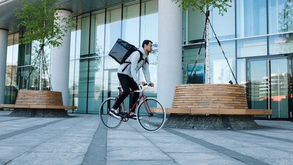 Ein Fahrradkurier liefert etwas mit einem Rucksack aus