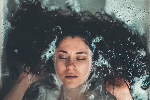 Eine Frau liegt in einem Floating-Becken