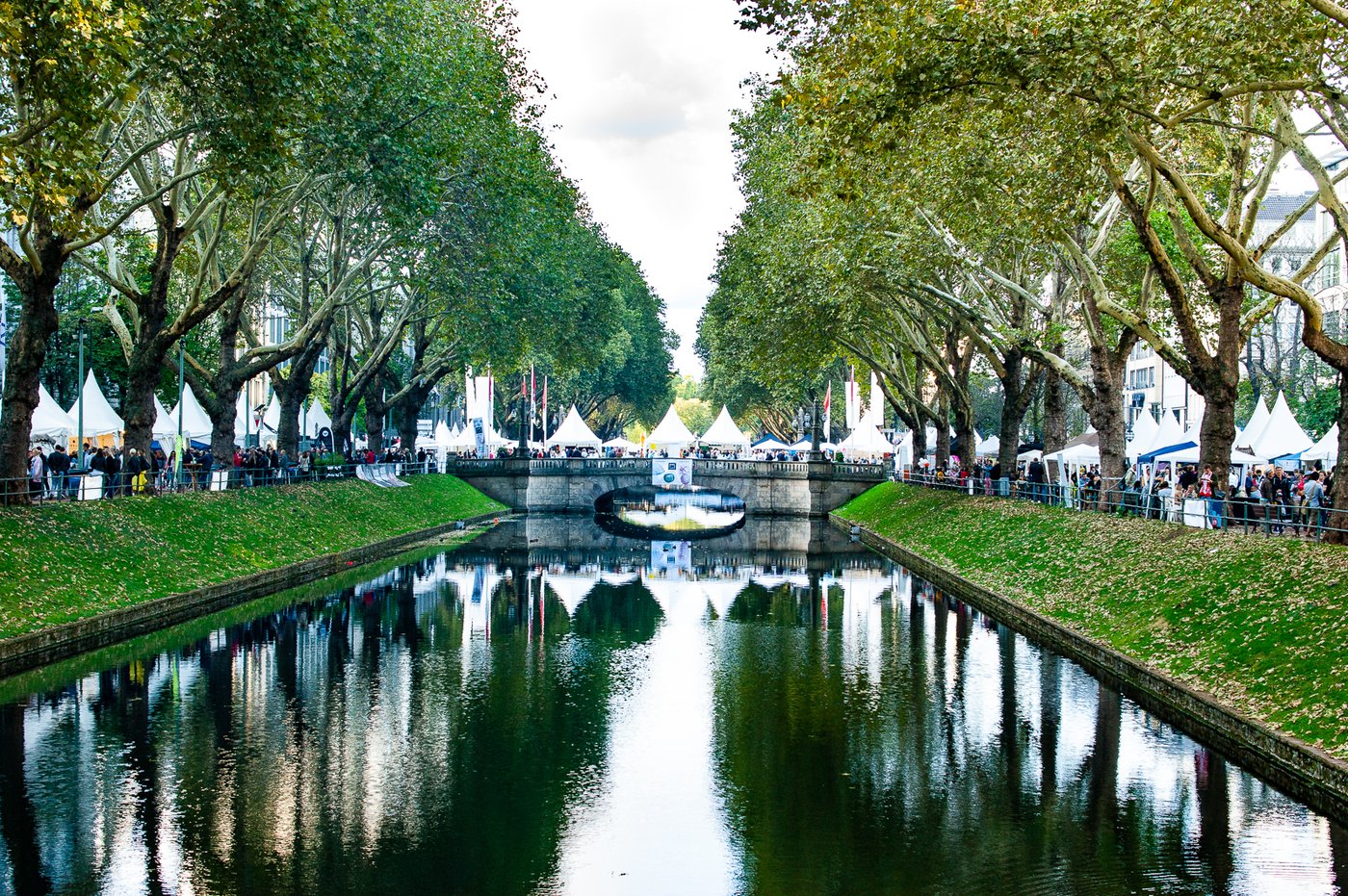 An der Königsallee in Düsseldorf stehen am Kanal Zelte eines Festivals.