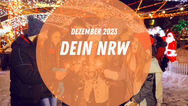 Eine Gruppe von Weihnachtsmarktbesucher:innen zündet Wunderkerzen an