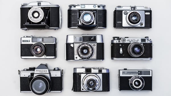 9 analoge Kameras in einem Quadrat angeordnet.