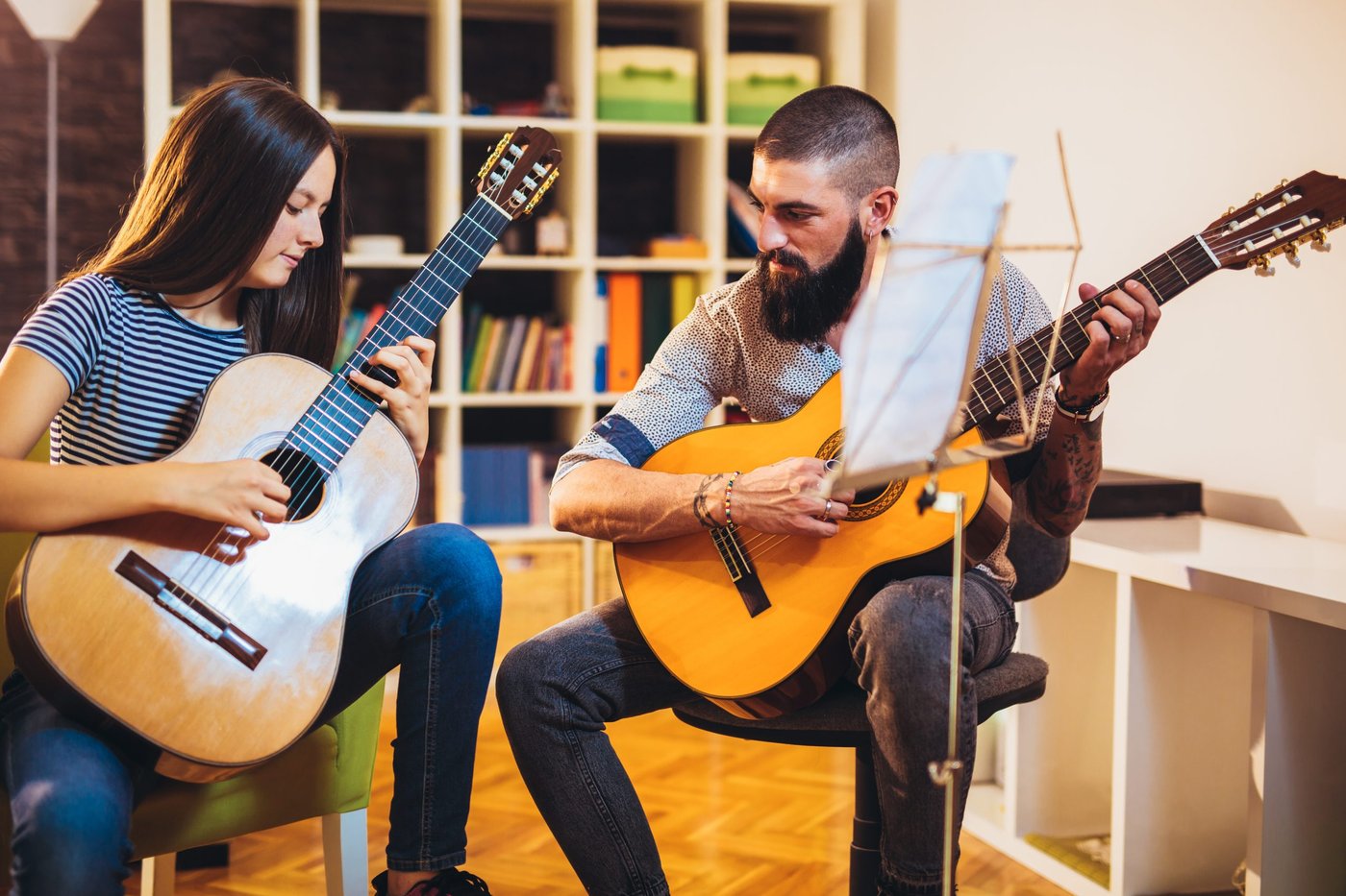 Gitarrenlehrer mit Schülerin.