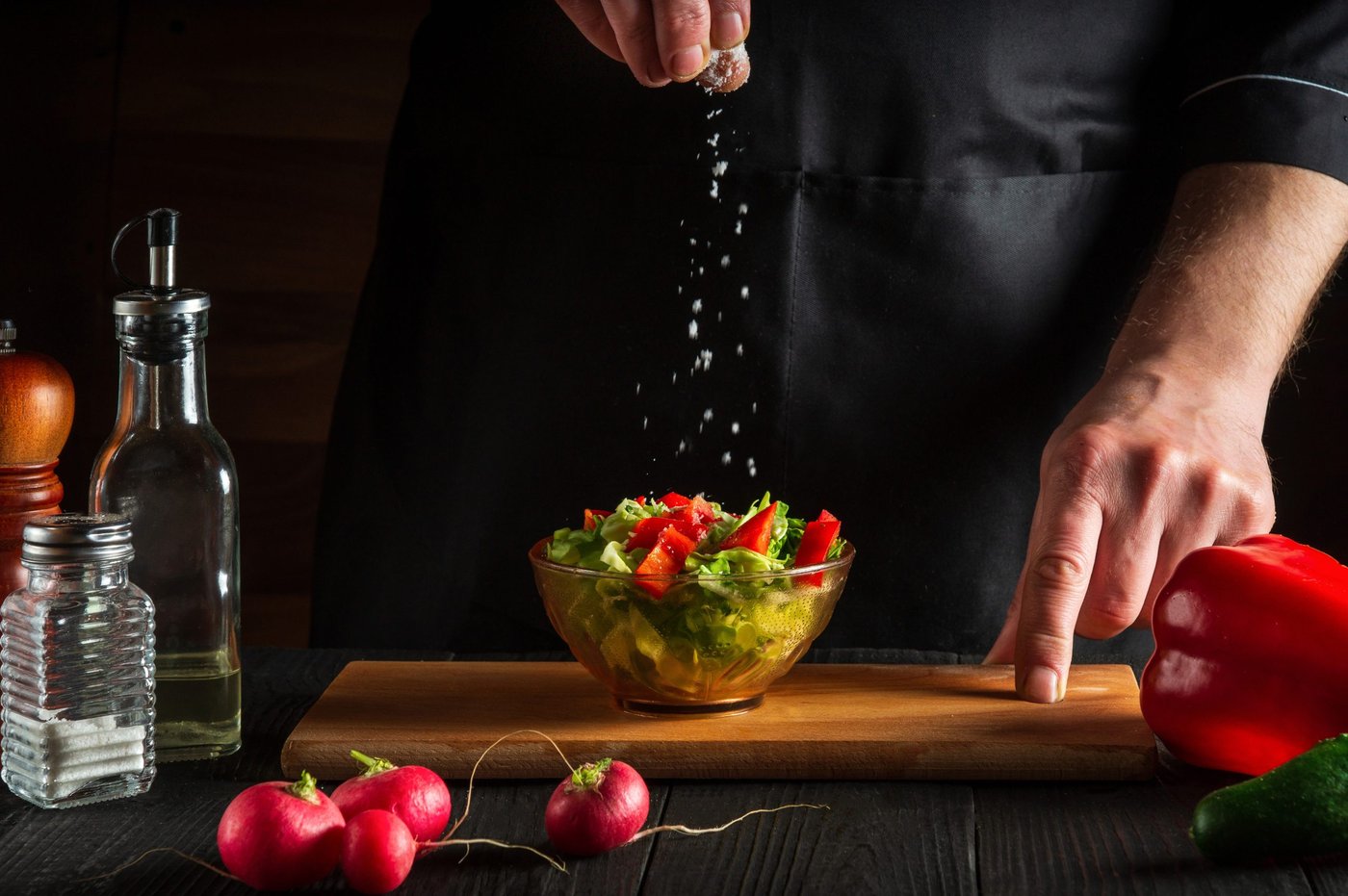 salz wird über einen salat gestreut
