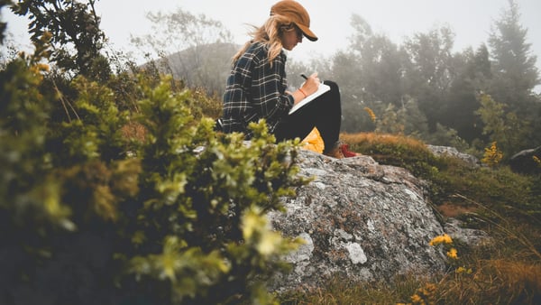 Frau beim Journaling in der Natur