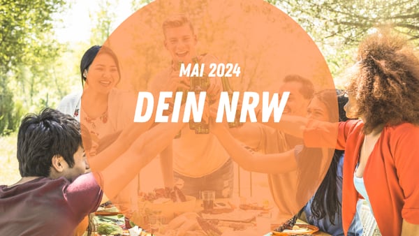 Eine Gruppe stößt im Biergarten miteinander an