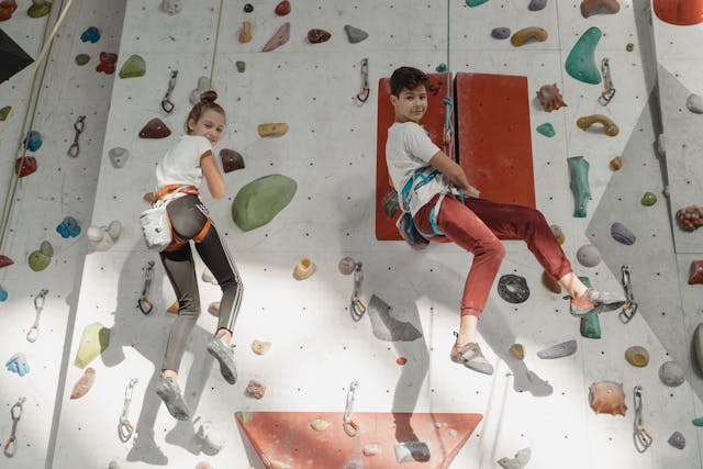 zwei Kinder an einer Kletterwand