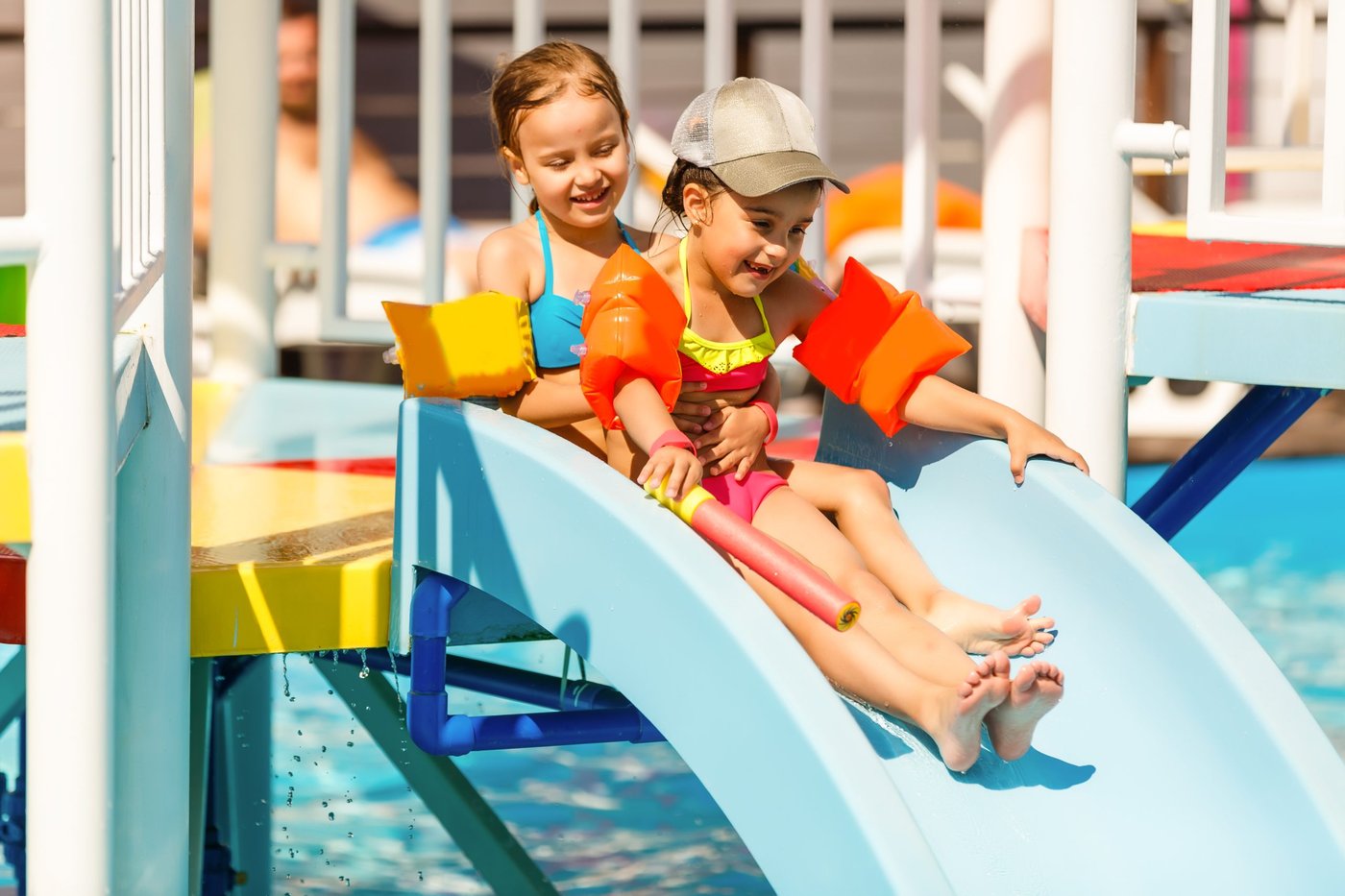 Zwei Kleinkinder rutschen auf einer altersgerechten Wasserrutsche