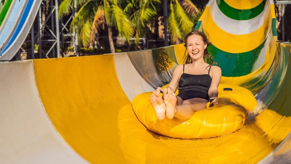 Eine Frau rutscht eine Wasserrutsche hinunter