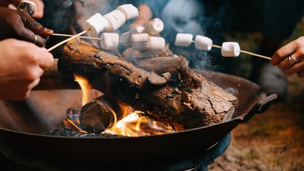 Marshmallows werden über einen Grill gehalten