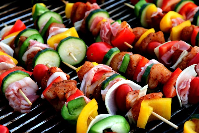 Verschiedene Grillspieße auf einem Grillrost