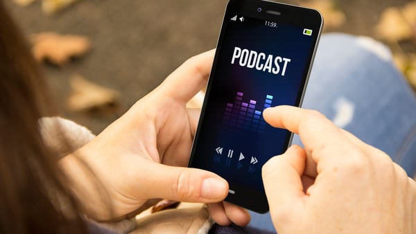 person hört podcasts auf ihrem handy