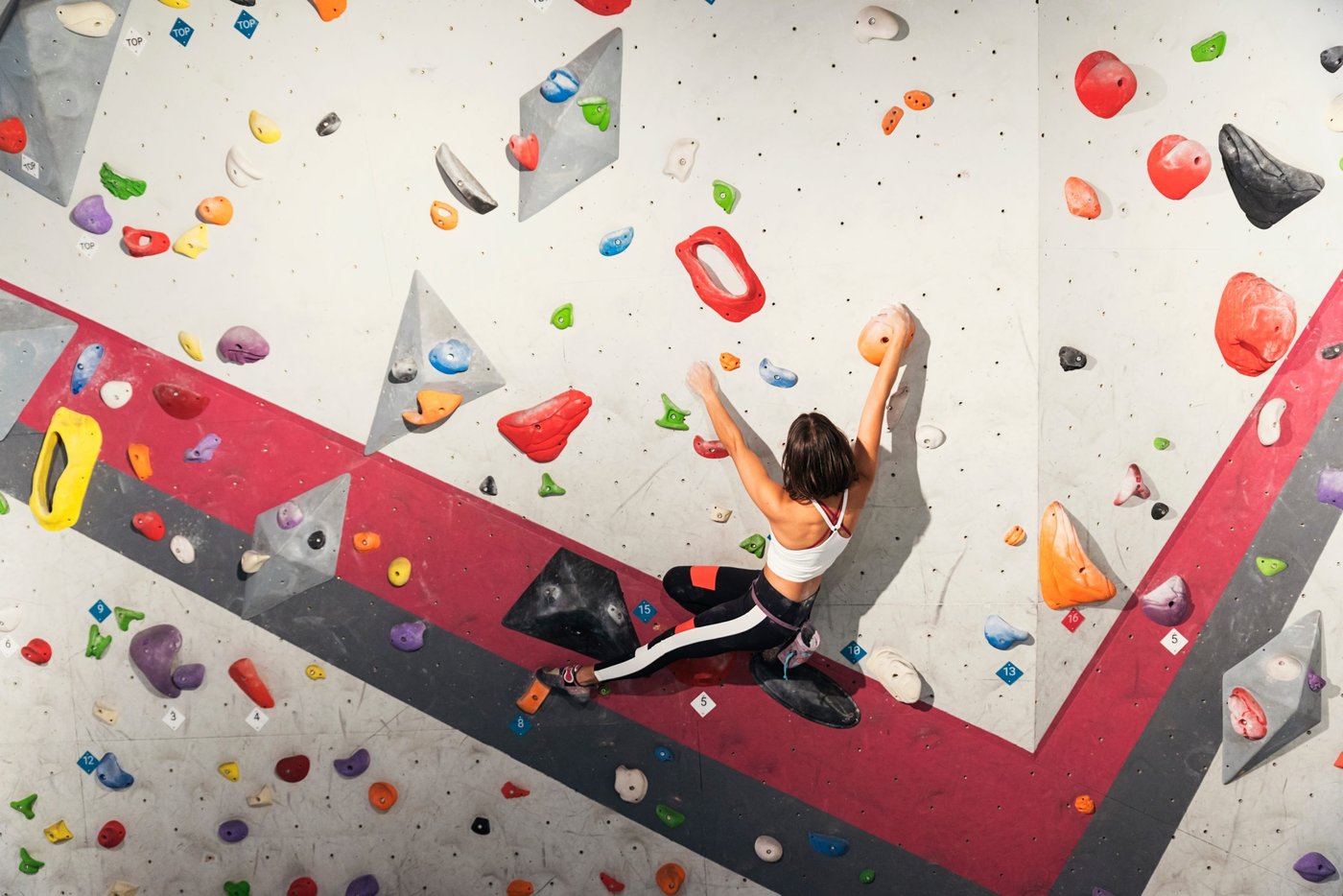 Woman practicing rock climbing on artificial wall indoors. Active lifestyle and