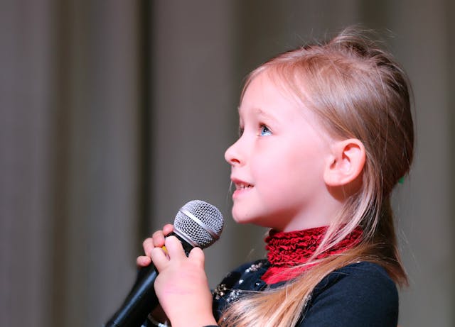 Ein Mädchen singt in ein Mikrofon