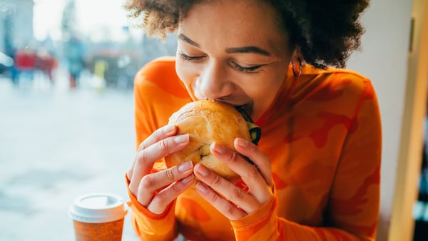 Junge Frau, die einen Burger isst