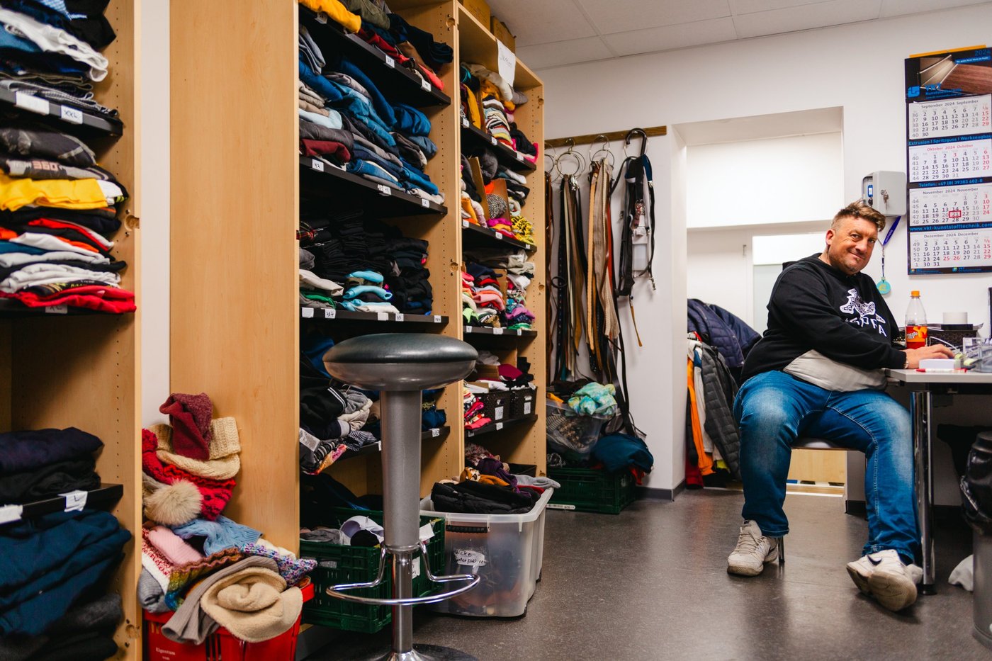 mitarbeiter der menschen im gast-haus kleidung austeilt