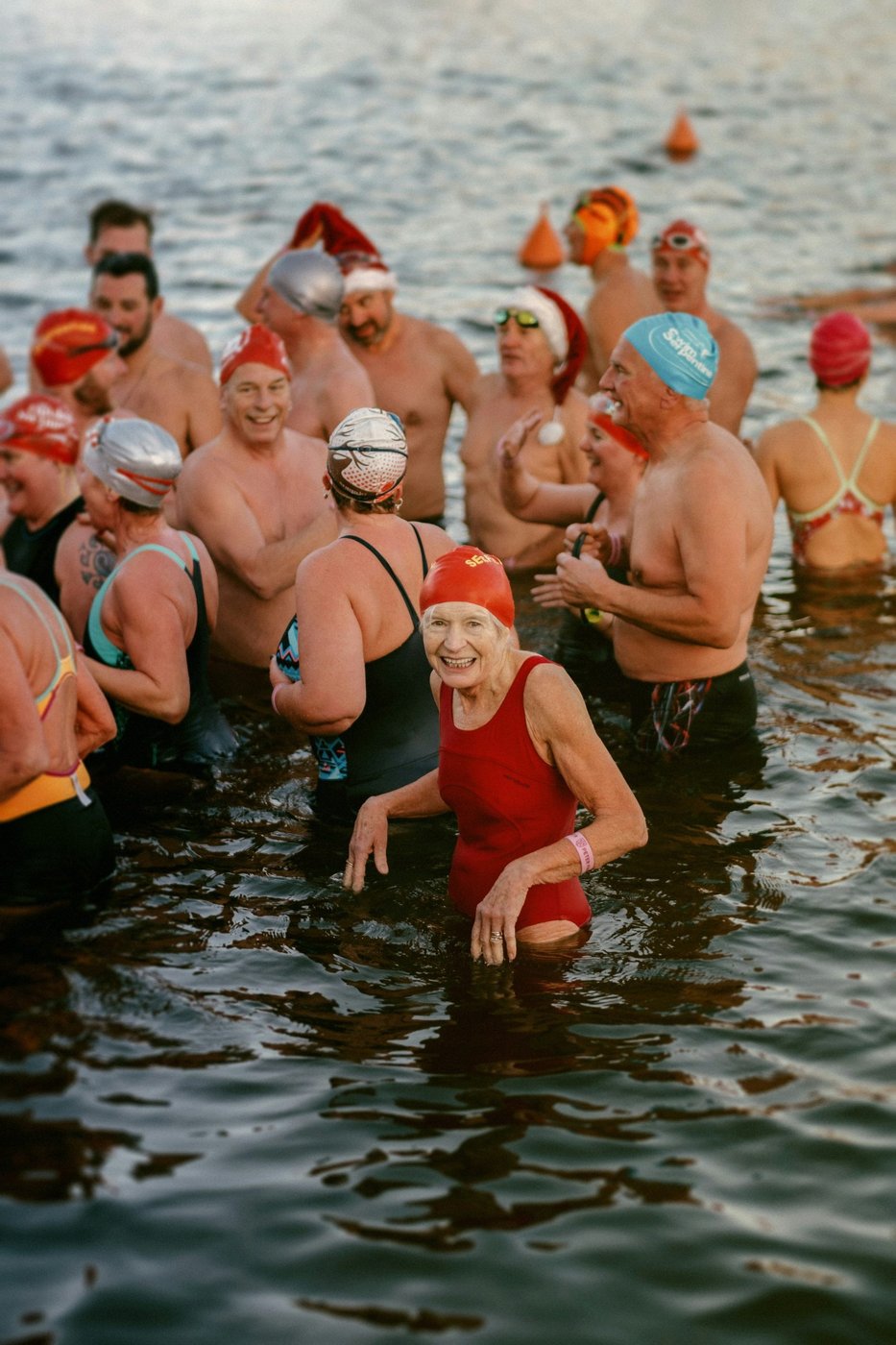 Menschen schwimmen mit Weihnachtsmützen