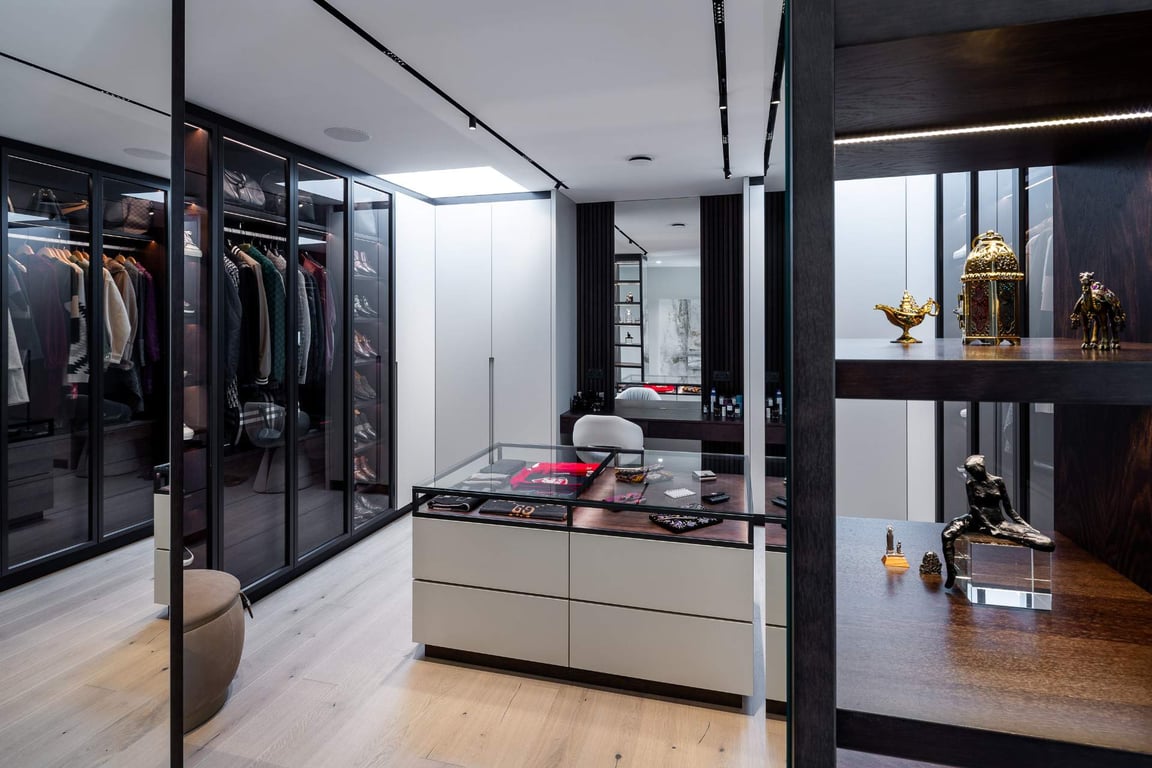 Walk-in closet with shelves displaying clothing, accessories, and decor.