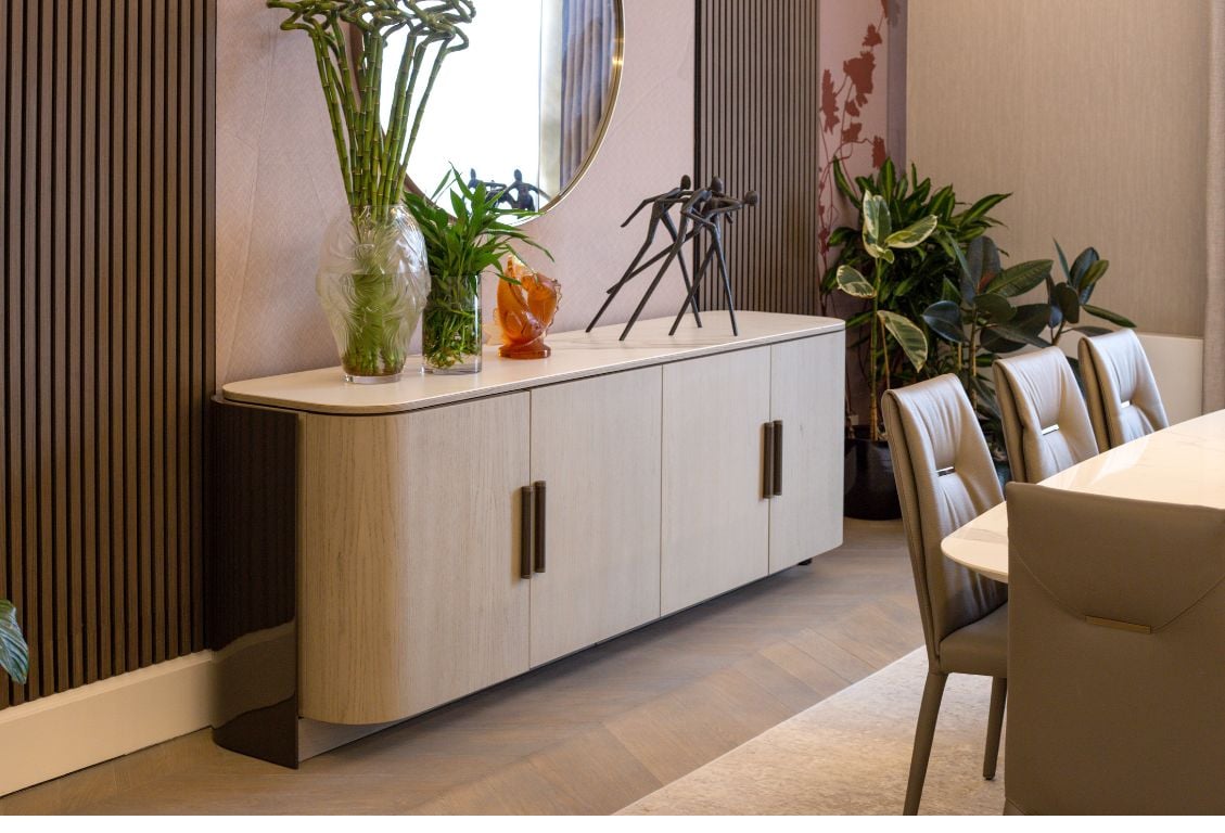 Contemporary dining room storage unit with plants and decorative sculptures.