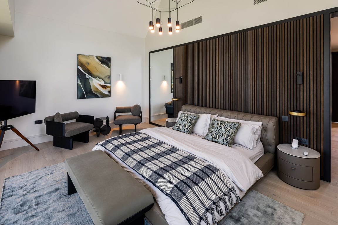 Stylish bedroom with black and white accents, geometric rug, and modern furniture.