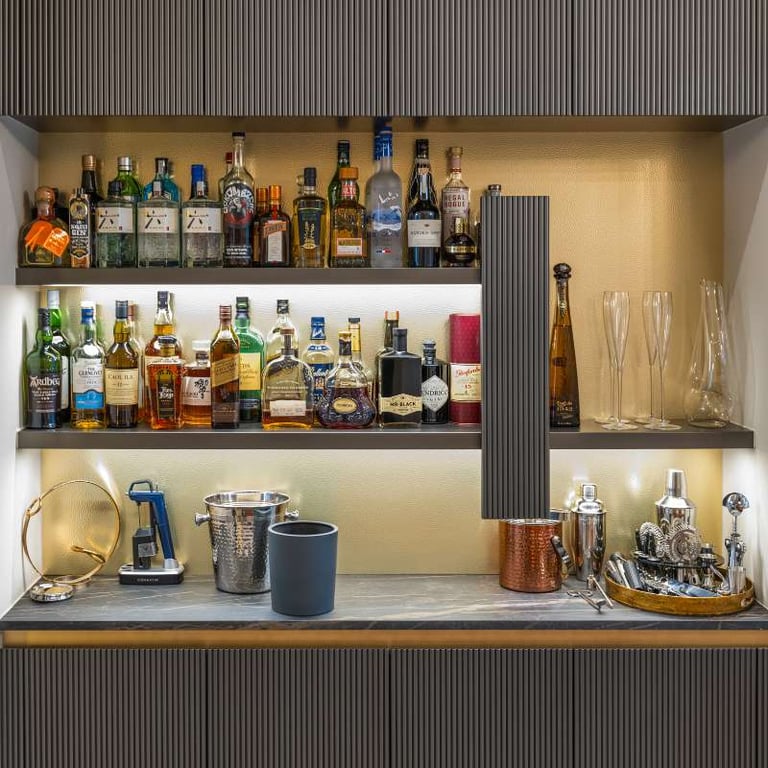 Stylish bar with shelves of liquor bottles and cocktail accessories.