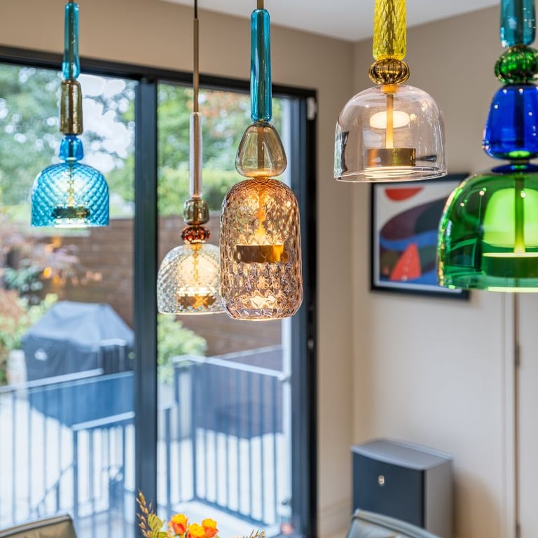 Colourful pendant lights hanging in a dining area with large windows