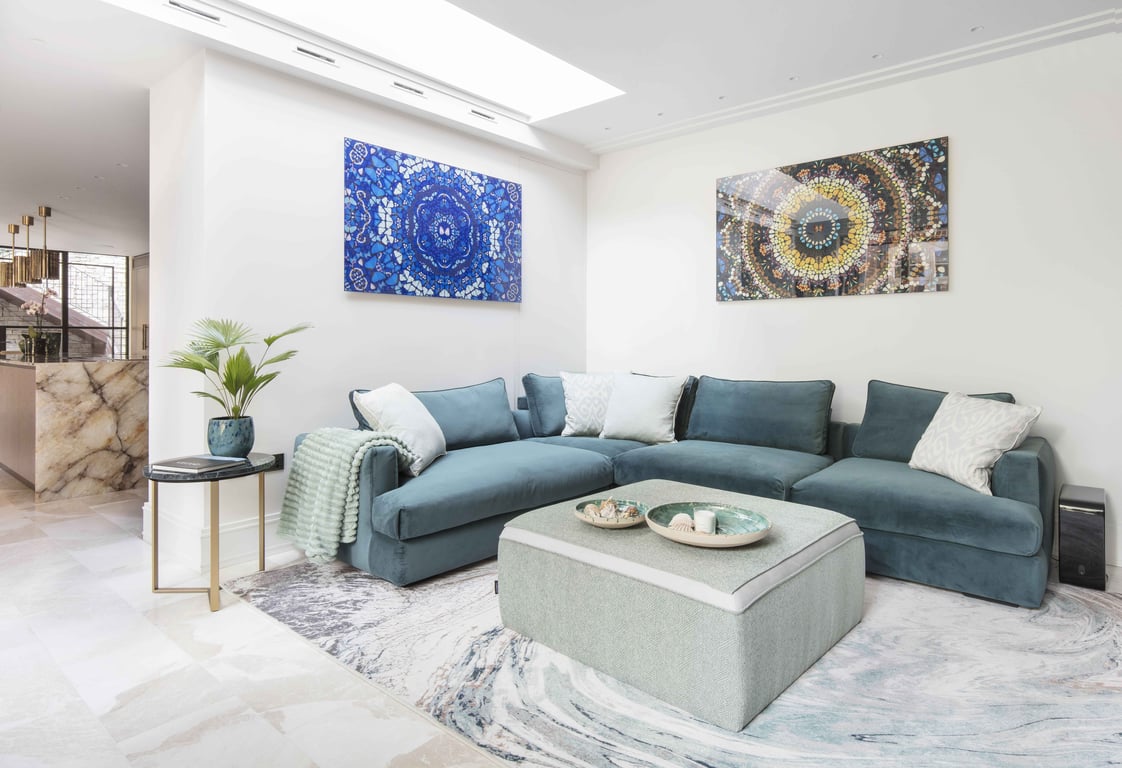 Stylish Hampstead living room with teal sofa, coffee table, and contemporary wall art.