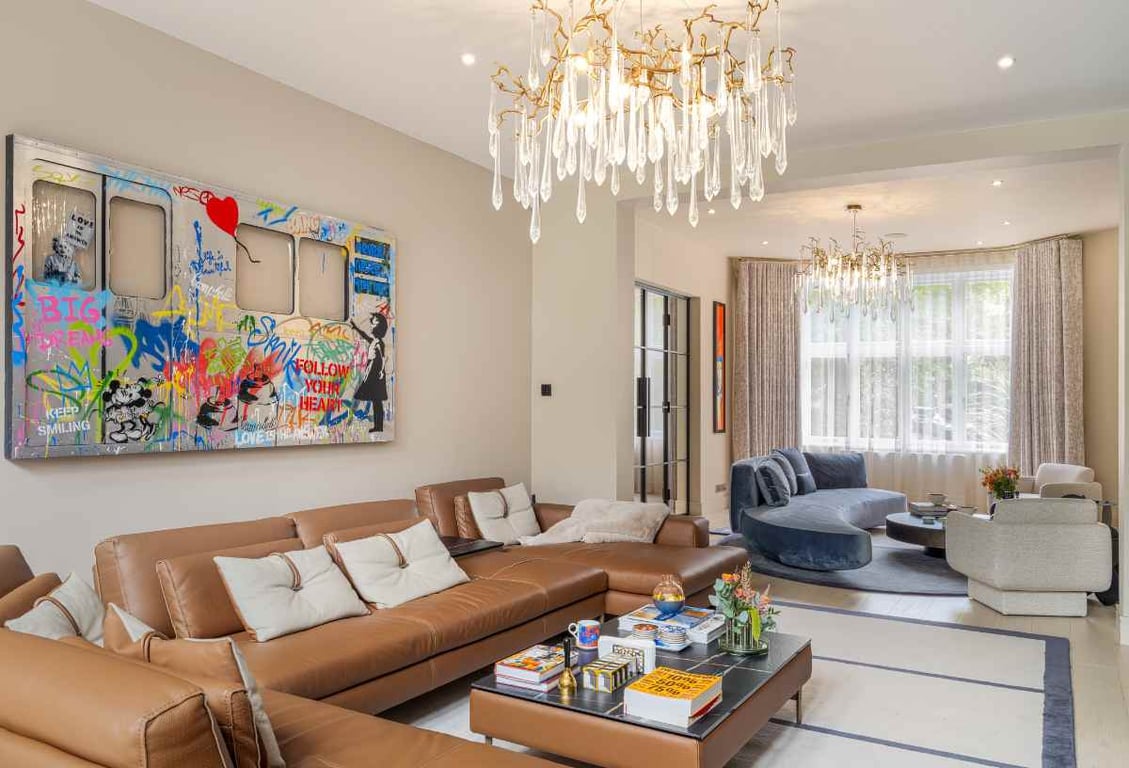 Living room with tan leather sofas, contemporary art, and large windows
