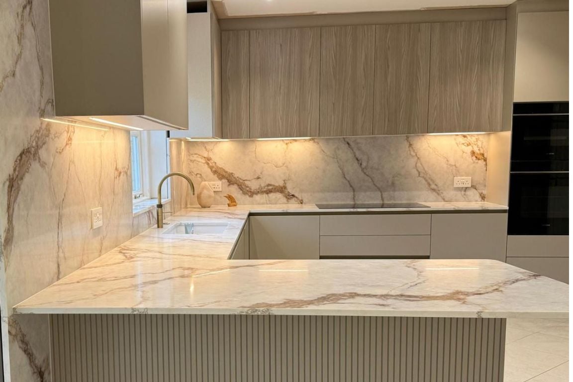 Contemporary kitchen with marble countertops, sleek cabinetry, and stylish lighting.