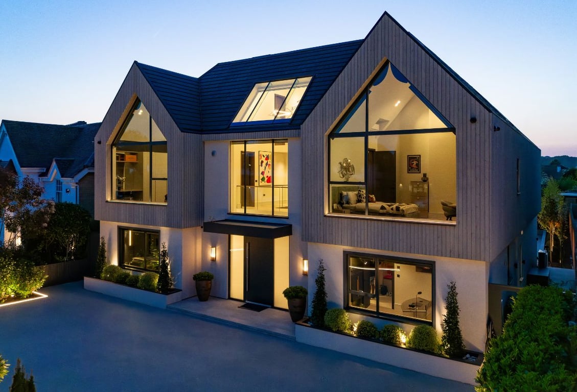 Spareleaze Hill modern home exterior with large windows and clean lines at dusk.