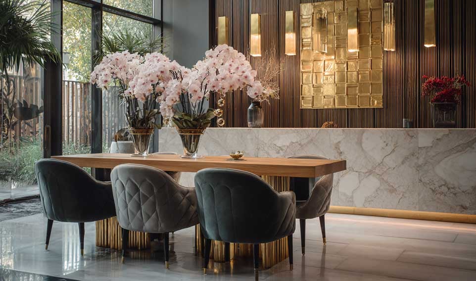 FCI London showroom dining area with velvet chairs, marble walls, and luxurious golden accents