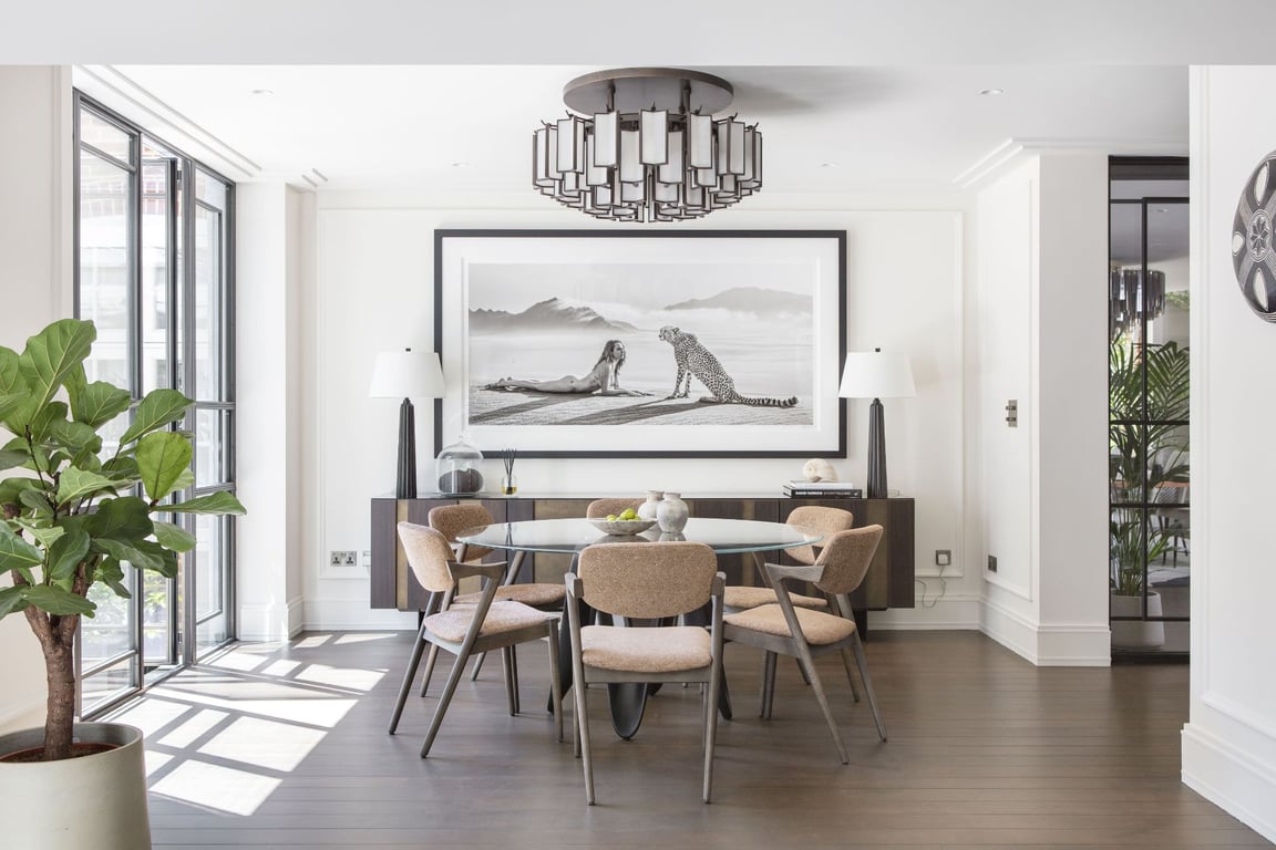 Bright dining area with stylish table, plants, and statement chandelier.