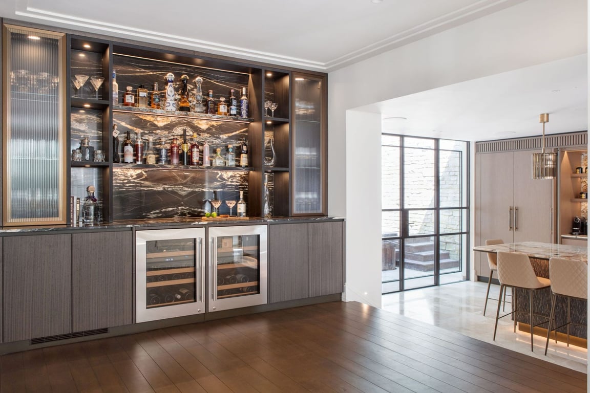 Elegant bar area with liquor bottles, wine coolers, and modern cabinetry.