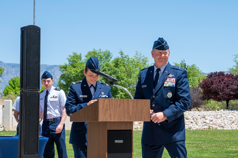 Newly commissioned Air Force officers stand at a podium during an AFROTC detachment commissioning ceremony