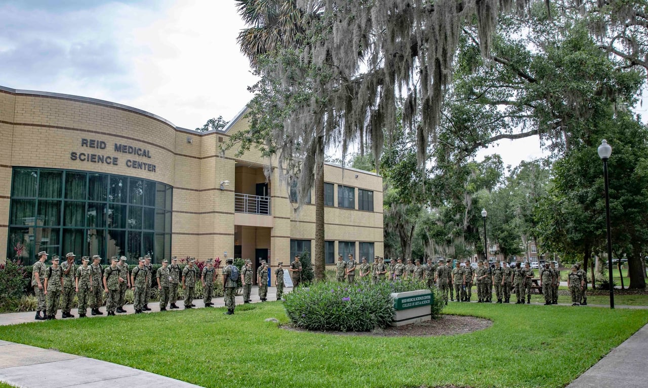 NROTC midshipmen stand in formation before a graduation ceremony