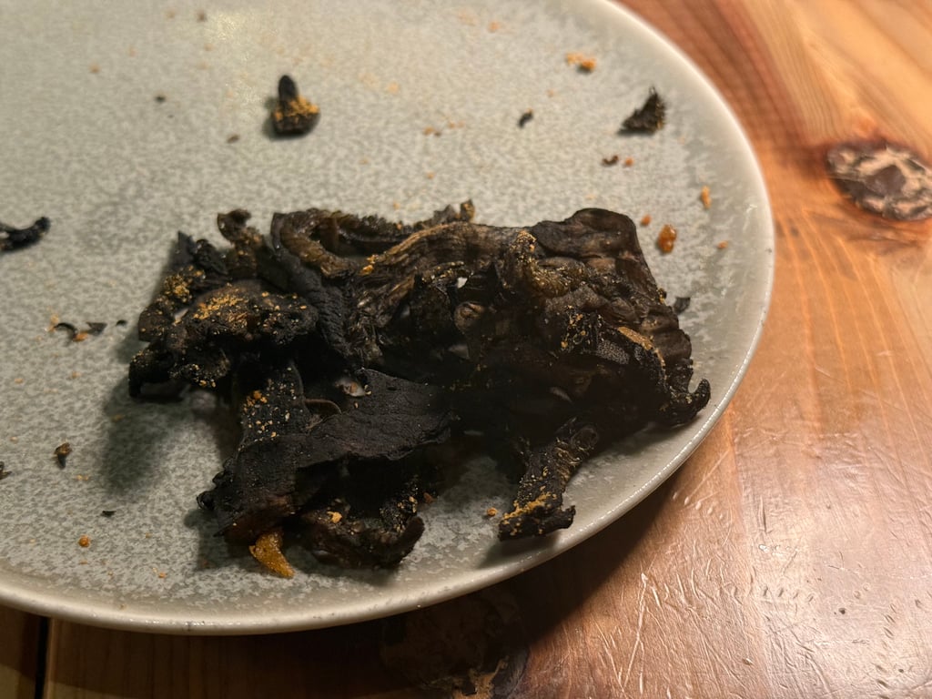 烤得很焦的香菇，上面淋了烏魚子粉