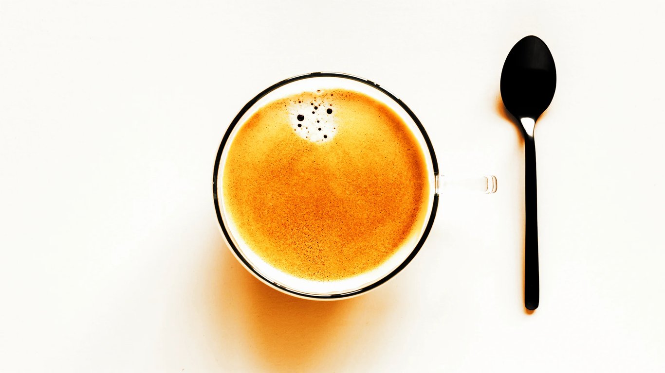 A small espresso cup beside a spoon, evoking the quiet ritual of slowing down and paying attention that underpins The Drawdown