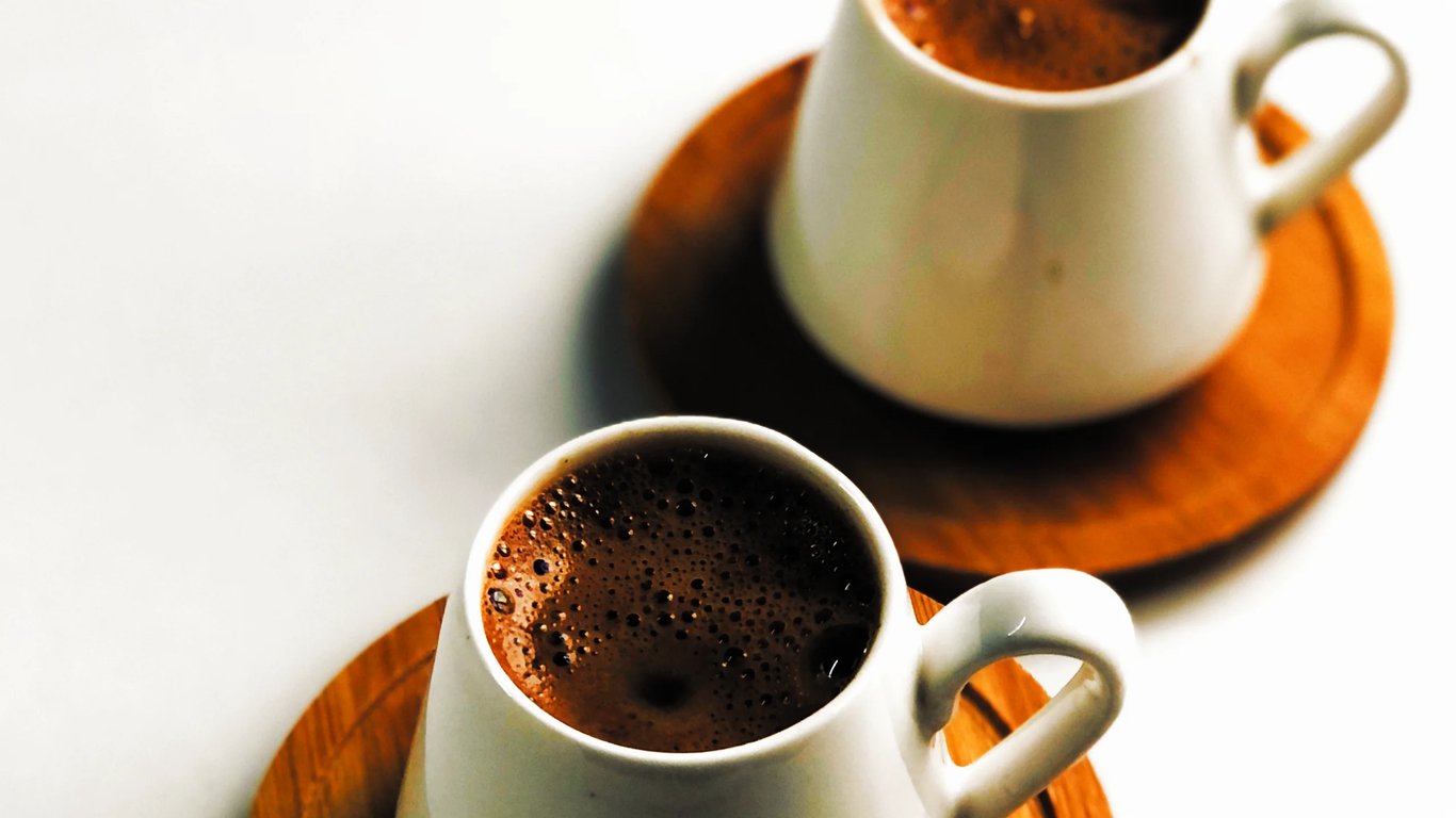 Two cups of coffee resting on a table, evoking the unhurried, conversational spirit of The Common Table