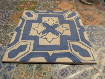 Half painted white tile with blue paint in traditional Portuguese style