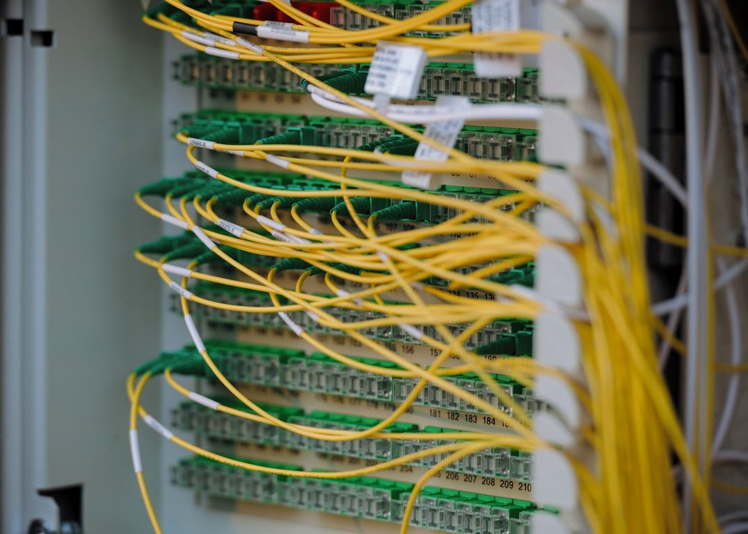 Fiber patch panel in a data center, illustrating Zoho AI agent timeout issues on large CRM datasets. Photo by Albert Stoynov on Unsplash